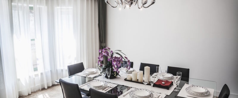 Dining room with modern furniture and chandelier.